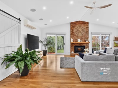 Bright, open living space featuring a distinctive brick fireplace and inviting natural light throughout.