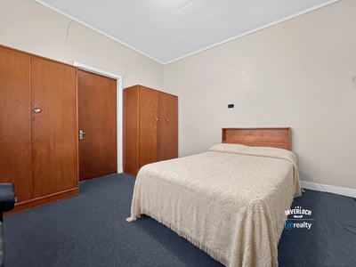 Spacious bedroom featuring a queen-size bed and built-in wardrobes, perfect for personalizing your space.