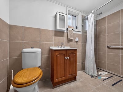Modern bathroom featuring a sleek shower and functional design with ample storage options.