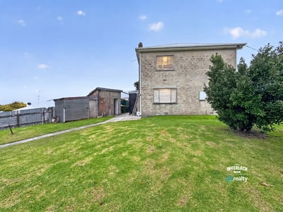 Spacious two-story home on a generous lot, featuring ample outdoor space and a detached shed.