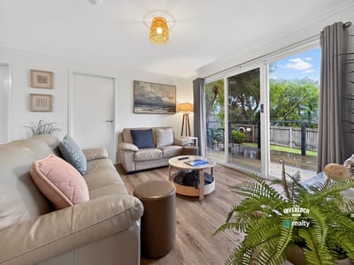 Bright living space featuring large windows that overlook a picturesque outdoor area, perfect for relaxation.