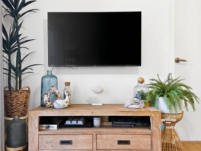 Modern living area featuring a sleek TV setup with tasteful decor and natural accents.