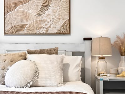 Bright and inviting bedroom featuring textured decor and warm, neutral tones for a cozy atmosphere.