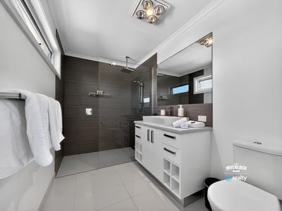 Modern bathroom featuring sleek finishes, spacious layout, and abundant natural light, perfect for relaxation.