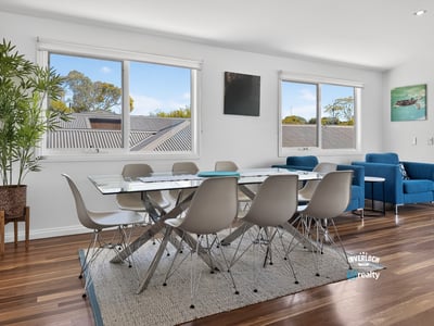 Bright and inviting dining area with large windows, modern furnishings, and beautiful wood flooring.