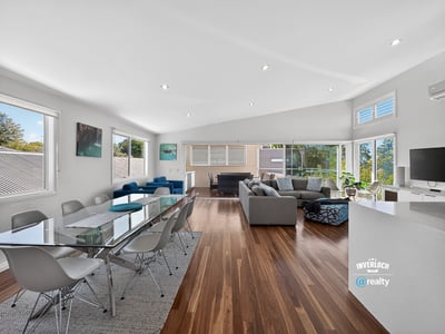 Spacious open-plan living area with abundant natural light, modern furnishings, and picturesque views.