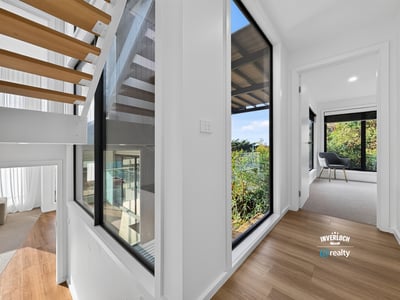 Bright, open hallways lead to inviting spaces with lush outdoor views and modern finishes.