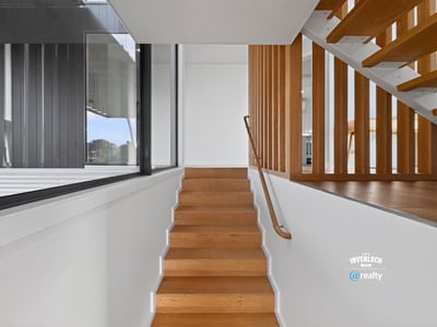 Modern staircase featuring sleek lines and natural light, seamlessly connecting spaces in a contemporary home.