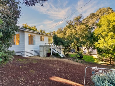 Well-maintained home nestled among lush greenery, featuring ample outdoor space and natural light throughout.