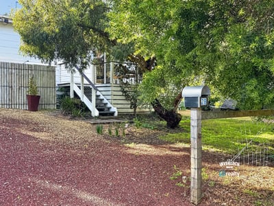 This property features a spacious yard with mature trees and a welcoming front porch, ideal for gatherings.