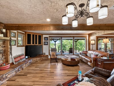 Spacious living area features a cozy layout with natural light, rich textures, and ample seating for gatherings.