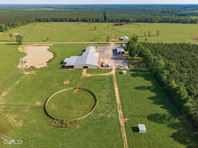Sprawling rural property featuring vast pastures, a pond, and multiple outbuildings, ideal for farming or recreation.