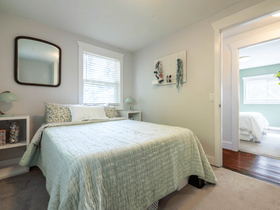 Bright bedroom featuring a cozy layout, large windows, and modern decor throughout for comfortable living.
