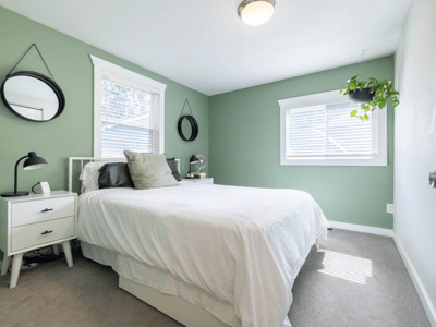 Bright and inviting bedroom featuring fresh paint, natural light, and modern touches for comfortable living.