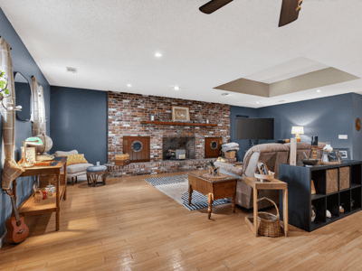 Spacious living area featuring a brick fireplace, modern amenities, and ample natural light for relaxation.