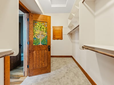 Walk-in closet offering ample shelving, hanging space, and distinctive wood detailing. Designed to combine organization, style, and character within the primary suite.