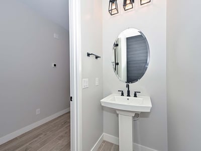 This well-appointed powder room blends modern design with bold light fixtures and clean lines perfect for guests and daily use.
