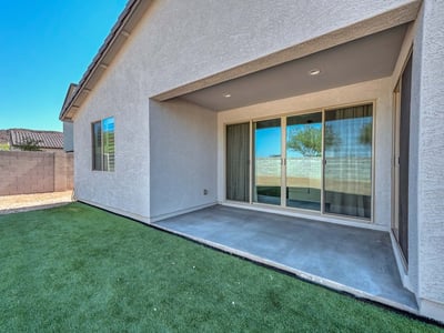 This covered patio is the perfect extension of indoor living ideal for shaded relaxation or hosting guests year-round. The smooth concrete flooring and direct access through sliding doors add comfort and convenience to this Peoria backyard retreat.