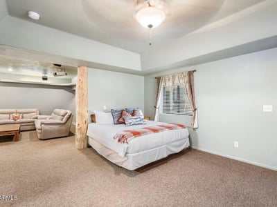 Bedroom paired with adjacent lounge space, featuring log columns and open flow ideal for guests or multi-generational living.