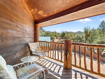 Wood deck with seating and forest backdrop, blending rustic charm with functional outdoor living.
