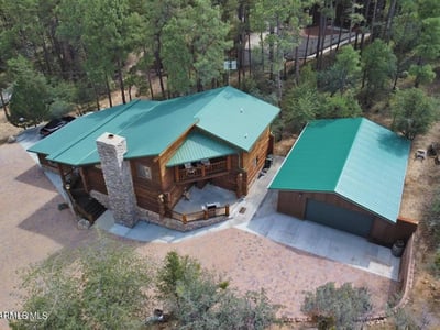 Aerial view highlighting the home s secluded setting, quality log construction, and detached garage. Surrounded by pines, this Prescott property offers privacy and a true mountain lifestyle.