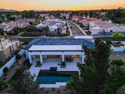 Aerial perspective highlights the home s pool, expansive patio, and updated roofline. Scottsdale living at its finest with modern updates.