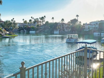 Waterfront view of calm blue waters surrounded by palm trees and luxury homes the ultimate lakeside lifestyle.