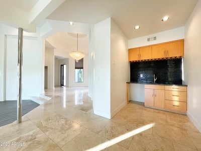 Built-in bar with sleek finishes and granite surfaces adds both convenience and luxury to the open living area.