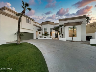Evening glow illuminates the home s bold lines and architectural beauty, framed by soft desert light.