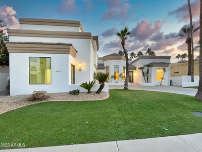 Elegant architectural profile captured at dusk, featuring clean stucco, modern windows, and softly lit entryway for a striking nighttime presentation.