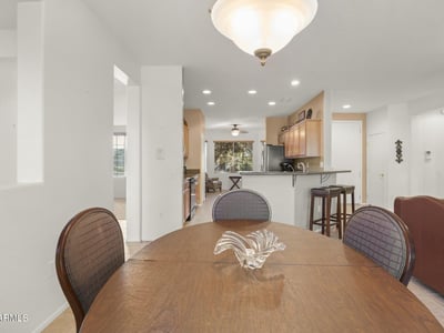 Sun-filled dining area with open access to the kitchen and living room, creating a perfect flow for entertaining and casual dining in this stunning Surprise home.