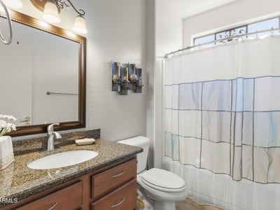 Granite counters, updated fixtures, and a framed mirror add a touch of elegance to this functional, modern guest bath.
