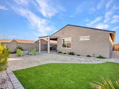 Featuring a blend of artificial turf and desert rock landscaping, this spacious backyard offers plenty of room for relaxation in Litchfield Park.