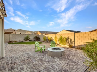 A fire pit area surrounded by desert greenery and mountain views adds charm and tranquility to this Litchfield Park backyard.
