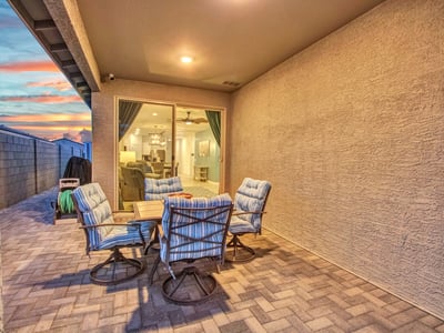 The spacious covered patio provides ample seating room, energy-efficient exterior lighting, and a welcoming transition to the landscaped yard ideal for enjoying Litchfield Park evenings.