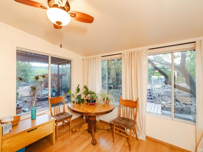 Warm wood cabinetry and vaulted ceilings complement the sunlight streaming through large windows. This kitchen combines modern convenience with rustic charm while framing beautiful views of the surrounding desert landscape.