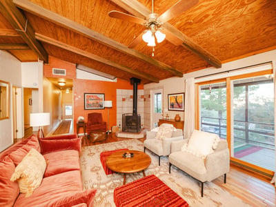 Featuring wood-beamed ceilings and warm finishes, this open living space blends comfort with rustic character. Large windows highlight the tranquil Hackberry surroundings and fill the room with natural light.