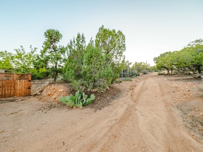 The natural dirt road winds through native vegetation, offering a secluded entrance to the property. A perfect introduction to the quiet, expansive lifestyle Hackberry provides.