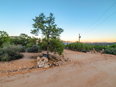 A quiet rural drive invites you into this Hackberry getaway, surrounded by lush desert vegetation and mountain silhouettes. The private approach enhances the property s secluded, nature-driven lifestyle.