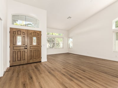 Bright Scottsdale living room with vaulted ceilings, wide windows, and modern flooring that enhances the open layout. Natural light fills the space, creating an inviting atmosphere perfect for everyday living.