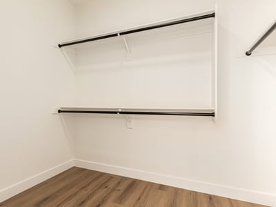 Generous walk-in closet with ample hanging rods and shelving for clothing storage. This Scottsdale closet provides convenient organization within the primary suite.