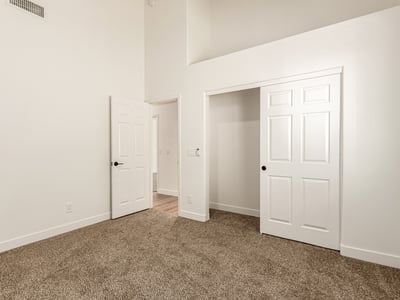 Bright guest bedroom with neutral finishes and soft carpeting. This Scottsdale room offers flexible use as a bedroom, home office, or hobby space.