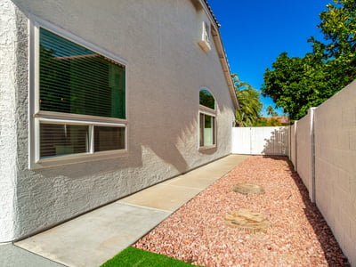 Side yard pathway with desert landscaping and gravel ground cover designed for easy upkeep. This Scottsdale outdoor area provides practical access around the home while maintaining a clean and organized appearance.
