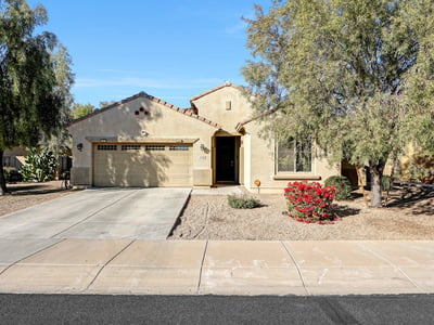 Clean front fa ade with attached two-car garage and mature desert landscaping, offering everyday convenience and curb appeal.