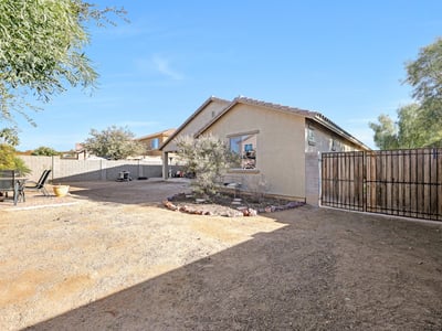 Side yard with gravel surface offering extra outdoor utility and flexible use options.
