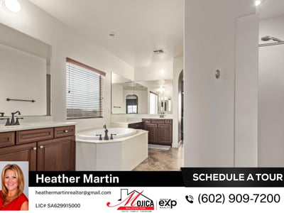 This expansive primary bathroom showcases dual vanities, soaking tub, and separate shower. Tile flooring and ample cabinetry enhance the comfort of this Glendale home with granite kitchen and pool.