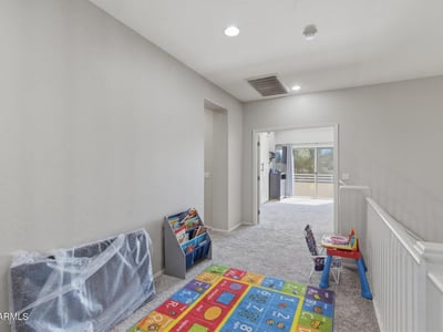 Open loft area overlooking the entryway, providing a flexible bonus space perfect for a playroom, second living room, study area, or media lounge in this Queen Creek home.