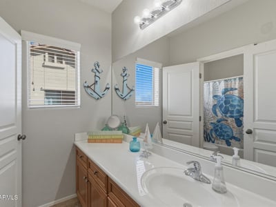 Clean and functional bathroom featuring a vanity with storage, large mirror, and shower tub combination designed for everyday convenience.