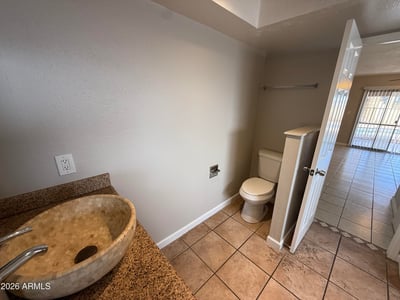 Bathroom layout highlighting a large soaking tub, granite vanity, and vessel sink. Natural lighting enhances the clean and spacious design of this Glendale home's primary bath.