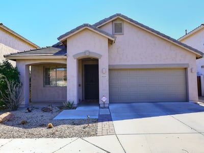 Full front view with covered entry, stucco exterior, and attached garage. This Phoenix home delivers style and functionality.